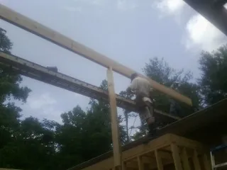 Carpenter setting a ridge beam over a new addition frame — Ice Dam Removal by Roofing Brothers in Hazen