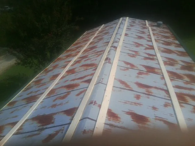 Rusted metal roof panels with new wood purlins before replacement — Storm Damage Roof Repair in Hazen by Roofing Brothers