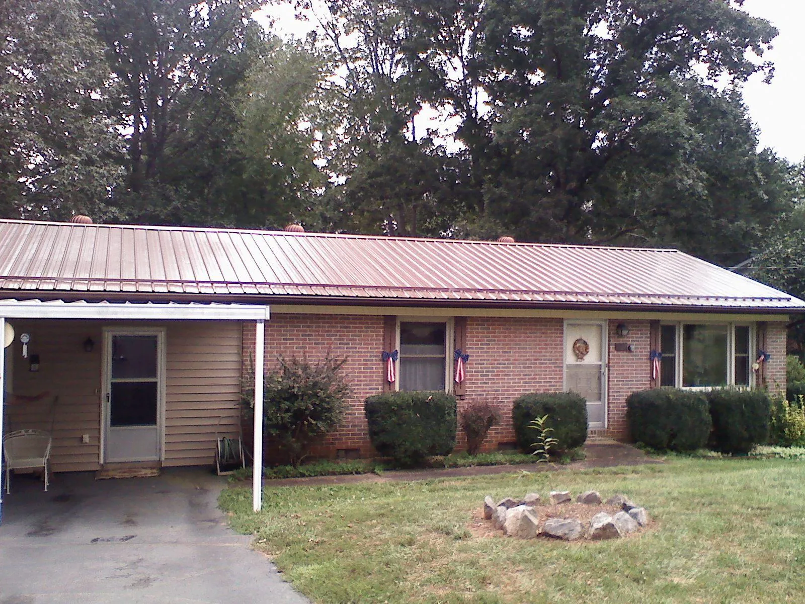 Bronze metal roof and carport on a brick ranch home — Roof Repair work by our crew in Hazen