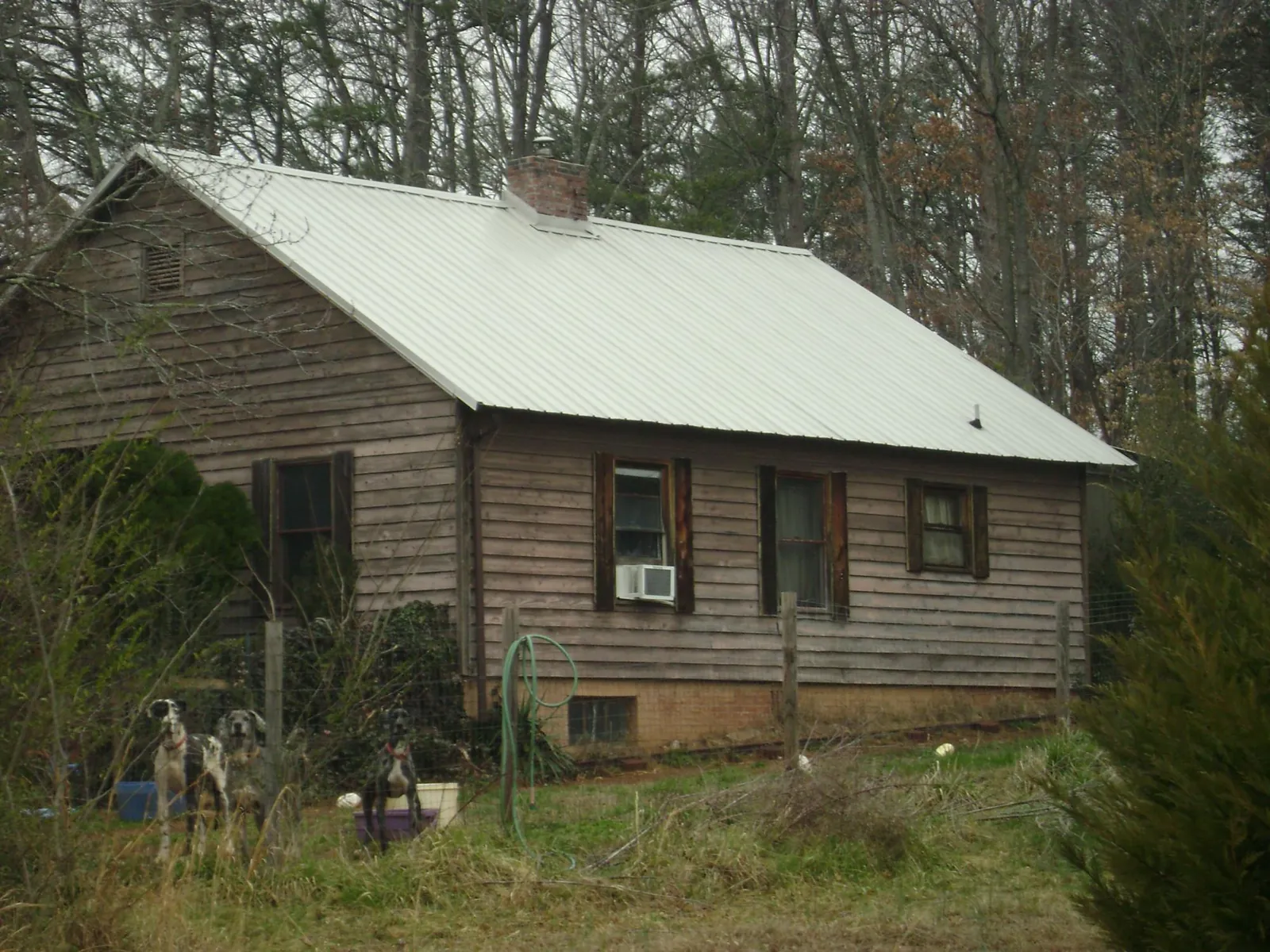 White metal roof on an old wood sided farmhouse, from a Metal Roof Installation job in Hazen